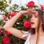 girl looks into the distance near the roses