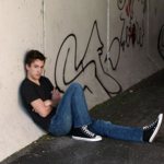 Lonely guy sitting on the ground in an underpass